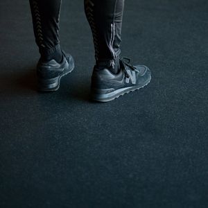 Sport shoes on a dark reflective gym floor surface.